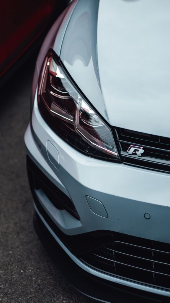 Detailed view of the front of a white sports car showcasing its sleek design and modern headlights.
